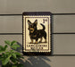 a sign with a dog illustration, mounted on a wall.