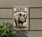 a rhinoceros, which is a large horned mammal, depicted on a sign.