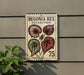 a postage stamp-like sign with a plant illustration, mounted on a wall next to a plant.