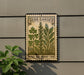 A metal sign with a vintage-style illustration of herbs and plants, mounted on a wall next to a plant.