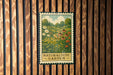 A vintage-style metal sign with a floral illustration is mounted on a wooden wall.