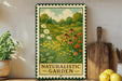 a framed painting of a naturalistic garden, with a wooden cutting board and a potted plant to the left.