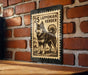 A metal sign with a black and white illustration of a Lapponian Herder dog, mounted on a brick wall.