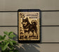 a black and white illustration of a dog, which appears to be a Lapponian Herder, mounted on a wall.