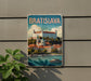 A vintage-style metal sign with the word "BRATISLAVA" prominently displayed, featuring a castle and a river in the background.