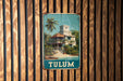 A vintage-style sign depicting a tropical resort with a palm tree and a building, mounted on a wooden wall.