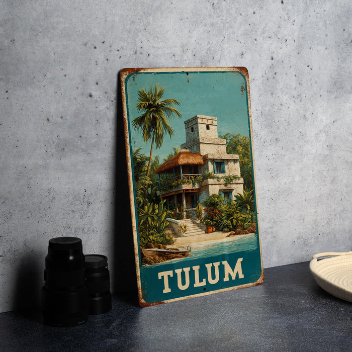 A vintage-style metal sign with a tropical house illustration, placed on a gray countertop next to some black camera lenses.