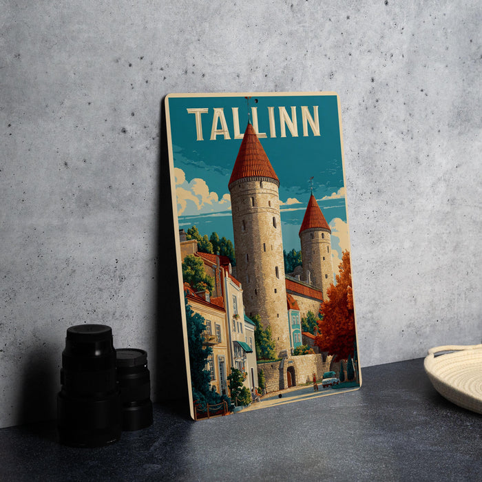 A framed poster of a castle with the word "TALLINN" written on it, displayed on a wall next to some black camera lenses.