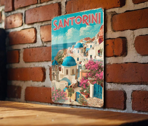 A vintage-style poster of Santorini, Greece, featuring colorful buildings, blue domes, and pink flowers against a bright blue sky.