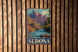A vintage metal sign with a scenic image of Sedona, a famous rock formation in Arizona, hanging on a wooden wall.