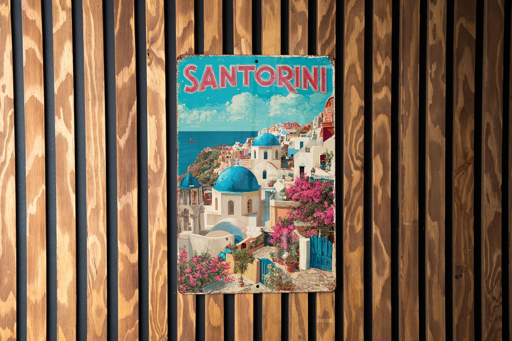 A vintage metal sign with the word "SANTORINI" in large letters, depicting a picturesque coastal town with white buildings, blue domes, and pink flowers.