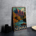 A vintage metal sign featuring a scenic image of Sedona, Arizona, with a river and mountains in the background.