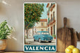 A vintage blue car is parked on a street in a picturesque town, surrounded by lush green trees and colorful buildings.