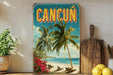 a vintage-style sign for Cancun, with a tropical beach scene and palm trees, placed on a shelf next to a cutting board and some potted plants.