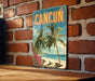 A vintage-style sign with the word "CANCUN" prominently displayed, featuring palm trees and a beach scene.