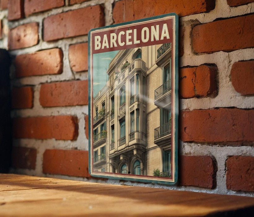 A vintage-style poster of a Barcelona building is displayed on a brick wall, with a wooden table below it.