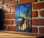 a wooden table with a framed painting of a deer with antlers hanging on the wall behind it.