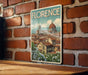 A vintage-style poster of Florence, Italy, featuring the iconic dome of the Cathedral of Saint Mary of the Flower, is displayed on a brick wall.