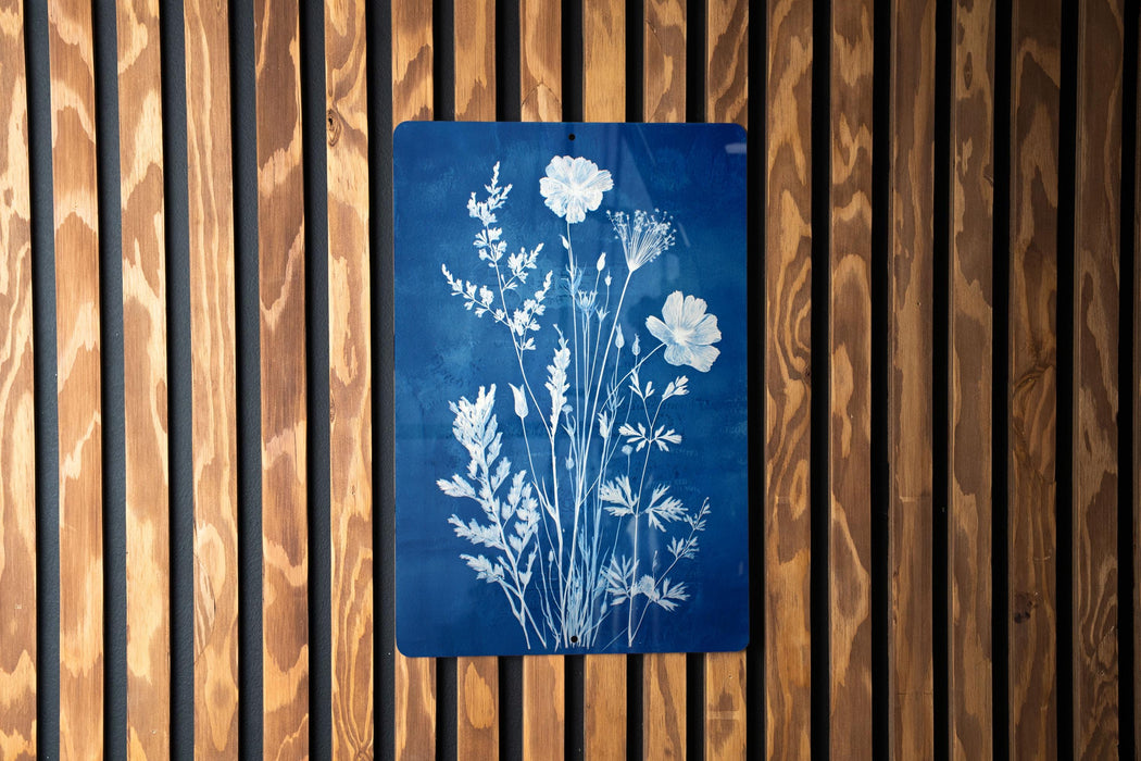 a blue sign with white floral designs on it, mounted on a wooden wall.