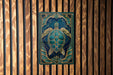 a large, ornate, and intricately designed turtle on a wooden background.