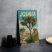 A vintage-style metal sign with the word "JOSUA" prominently displayed, featuring a desert landscape with a palm tree and other desert plants.