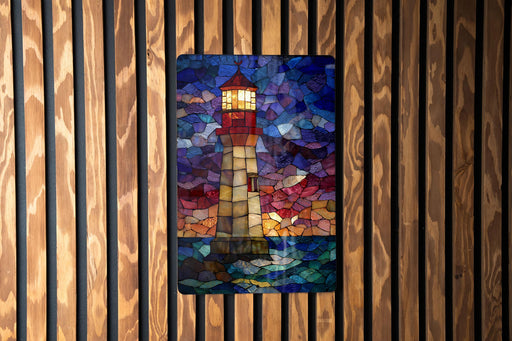 A stained glass lighthouse with a colorful mosaic pattern is displayed on a wooden wall.