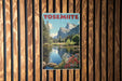 A vintage-style poster of Yosemite National Park, featuring a scenic landscape with mountains, trees, and a lake, is displayed on a wooden wall.