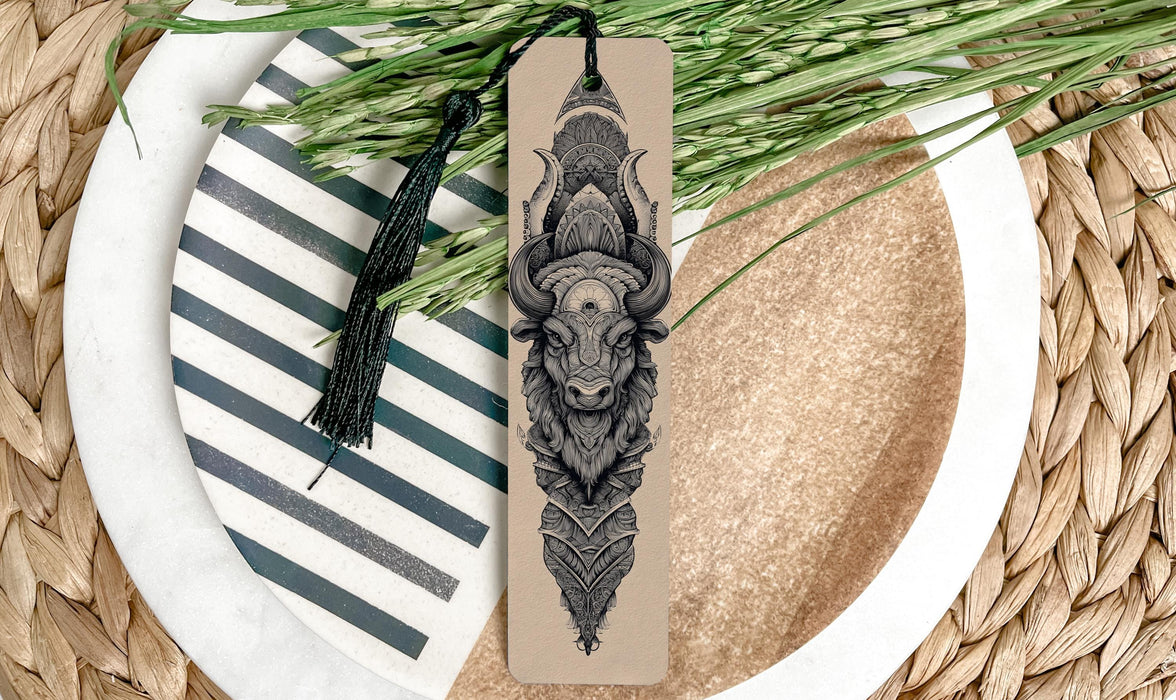 A decorative bookmark with a detailed illustration of a bull's head is placed on a plate with a striped pattern.