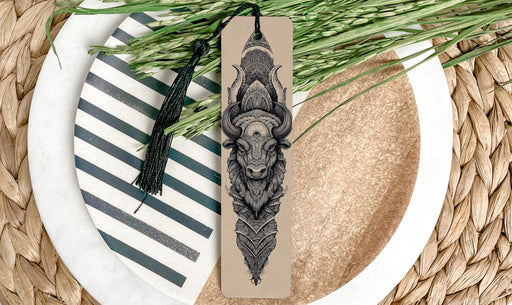 A decorative bookmark with a detailed illustration of a bull's head is placed on a plate with a striped pattern.