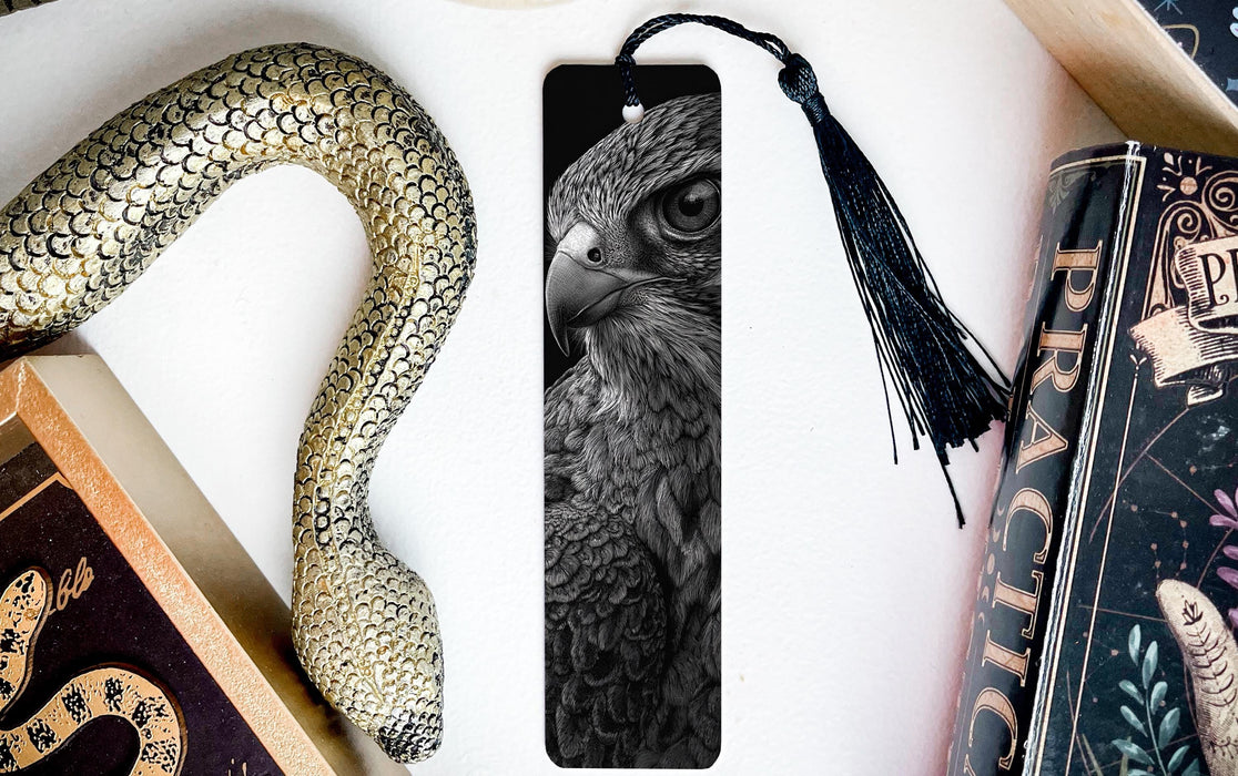 a close-up of a bird's eye bookmark with a black and white photo of a bird's eye on it, surrounded by various objects such as a snake, a book, and a tassel.