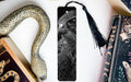 a close-up of a bird's eye bookmark with a black and white photo of a bird's eye on it, surrounded by various objects such as a snake, a book, and a tassel.