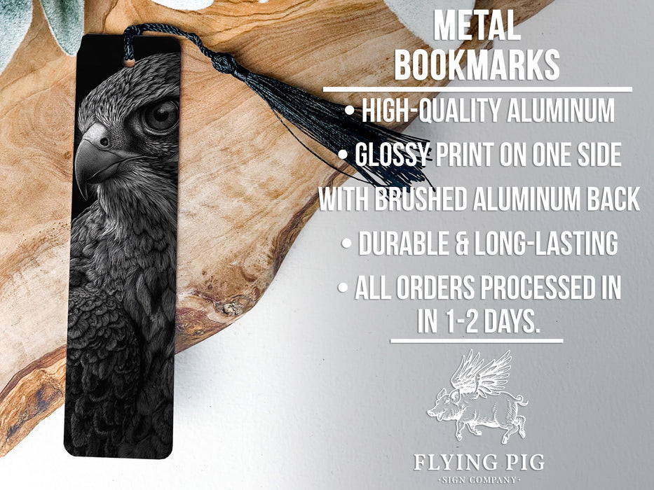 a close-up of a metal bookmark with a detailed black and white image of a bird of prey, likely a hawk or falcon, on it. The bookmark has a black tassel attached to it.
