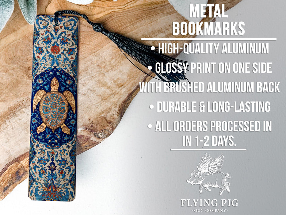 a metal bookmark with a detailed design, placed on a wooden surface.