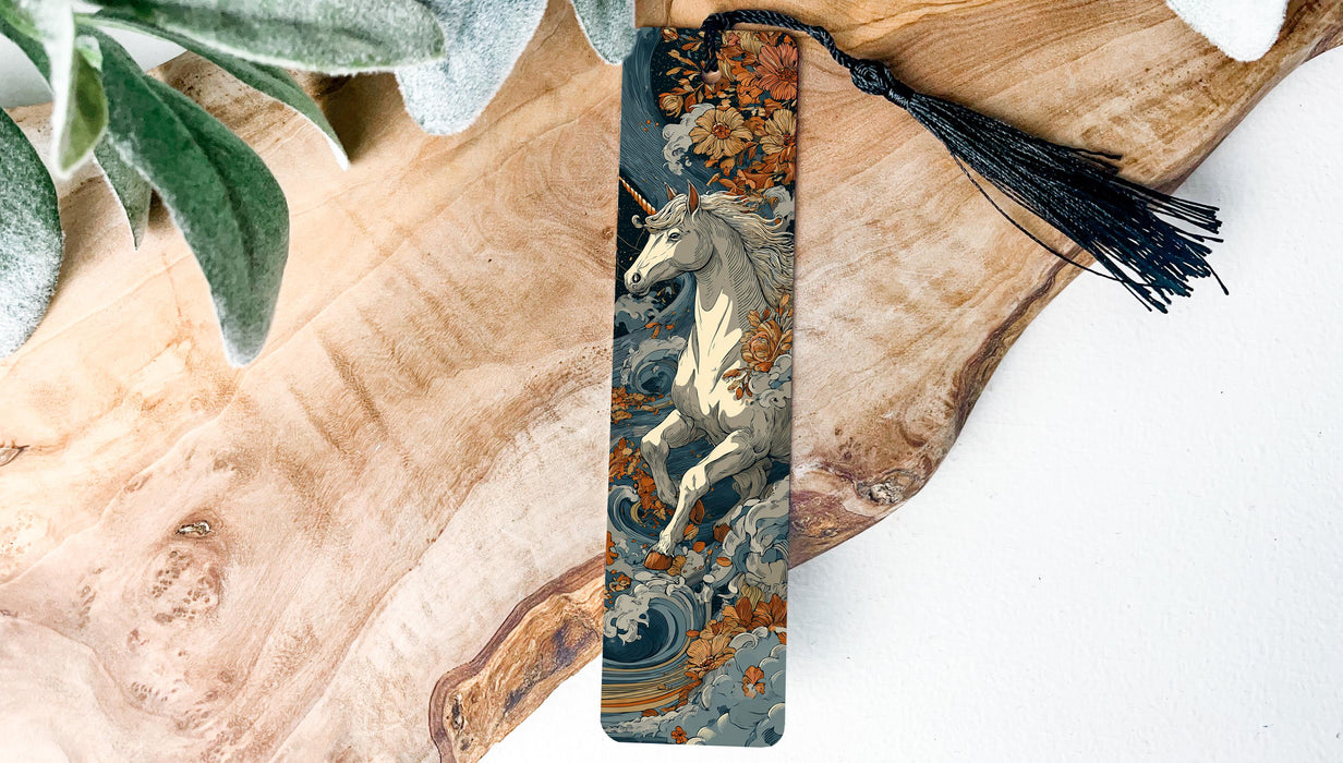 A decorative bookmark featuring a white unicorn with a floral design on a wooden surface.