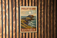 A vintage postage stamp from Australia depicting a scenic coastal landscape with a rocky island and ocean in the background.