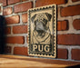 A wooden table with a vintage-style pug dog stamp on the wall.