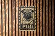 A pug dog is depicted on a postage stamp-like sign, which is mounted on a wooden wall.