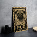 A wooden sign featuring a pug dog illustration is displayed on a table, accompanied by a stack of black camera lenses and a white dish.