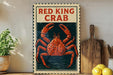 a vintage-style sign with the text "Red King Crab" and an illustration of a large red crab. The sign is displayed on a wooden shelf, with a potted plant to the left and a wooden cutting board to the right.
