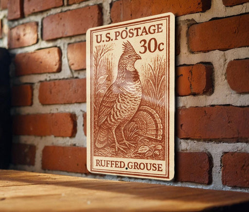A wooden plaque with a U.S. postage stamp design, featuring a bird and text indicating it is a postage stamp from Ruffled grouse.
