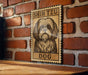 A wooden table with a framed poster of a Shih Tzu dog on it, mounted on a brick wall.