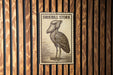 A sign featuring a stork, a large wading bird, is displayed against a wooden background.