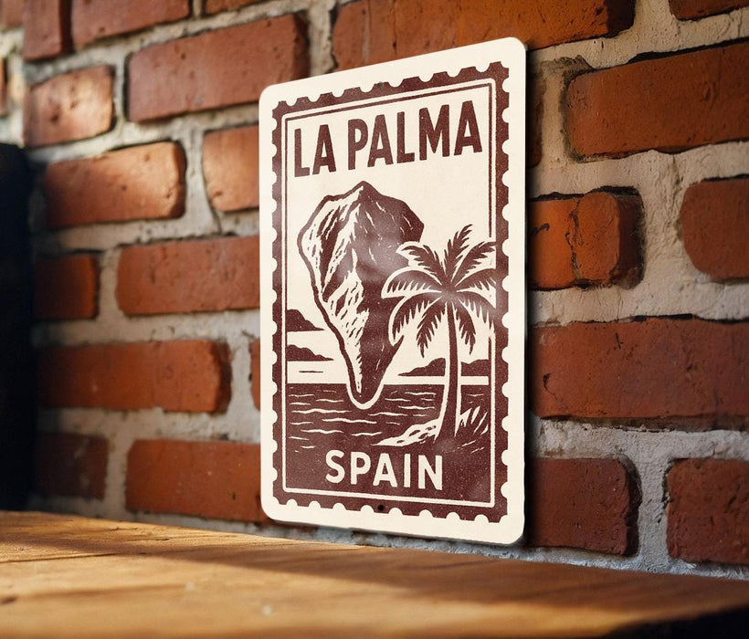 A sign with the text "LA PALMA" and "SPAIN" printed on it, mounted on a brick wall.