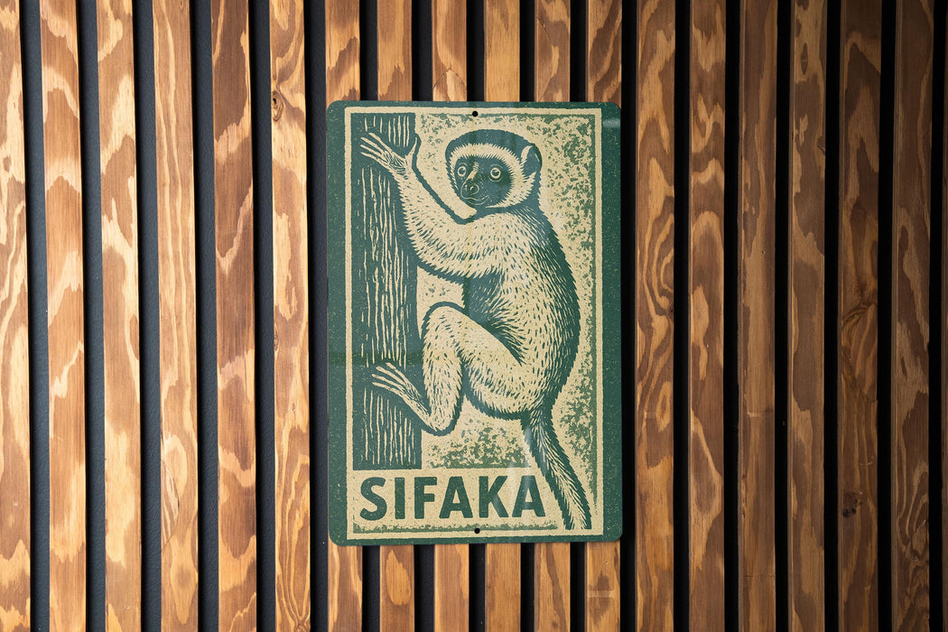 A metal sign with a monkey illustration is mounted on a wooden wall.