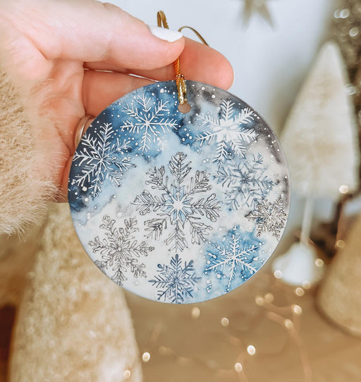 a person holding a snowflake ornament in their hand