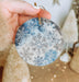a person holding a snowflake ornament in their hand
