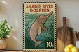 A vintage-style stamp depicting an Amazon River dolphin, with the text "AMAZON RIVER DOLPHIN" and a price of 10 cents. The stamp is displayed on a shelf next to a potted plant and a wooden cutting board.