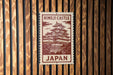 A sign for Himeji Castle, a famous landmark in Japan, is displayed on a wooden wall.