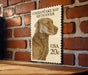 A wooden table with a framed image of a dog, specifically a Chesapeake Bay Retriever, on it.