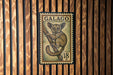 A postage stamp featuring a lemur, a type of primate, is displayed on a wooden wall.